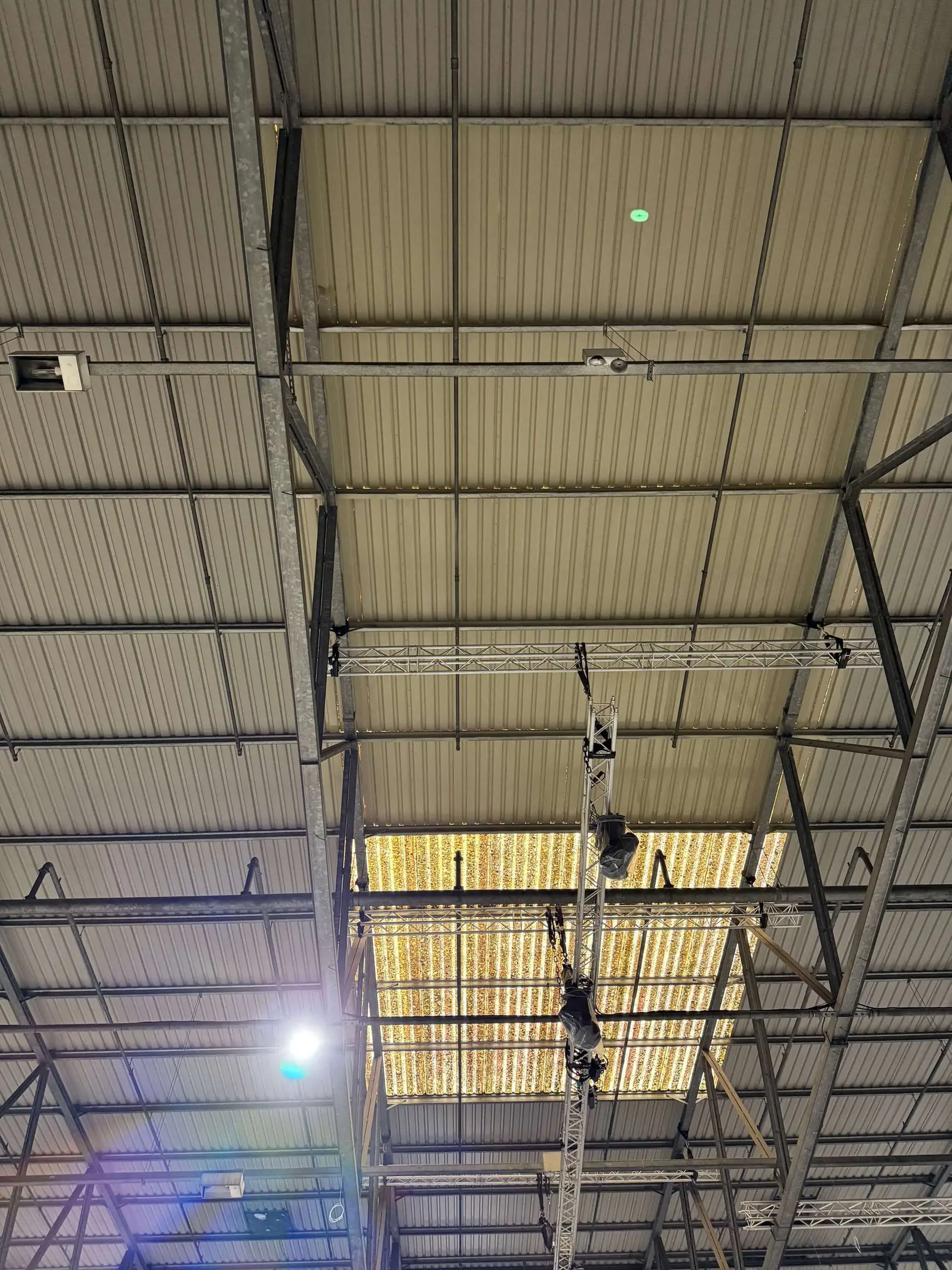 Warehouse roof panels and steel trusses with a suspended lighting rig