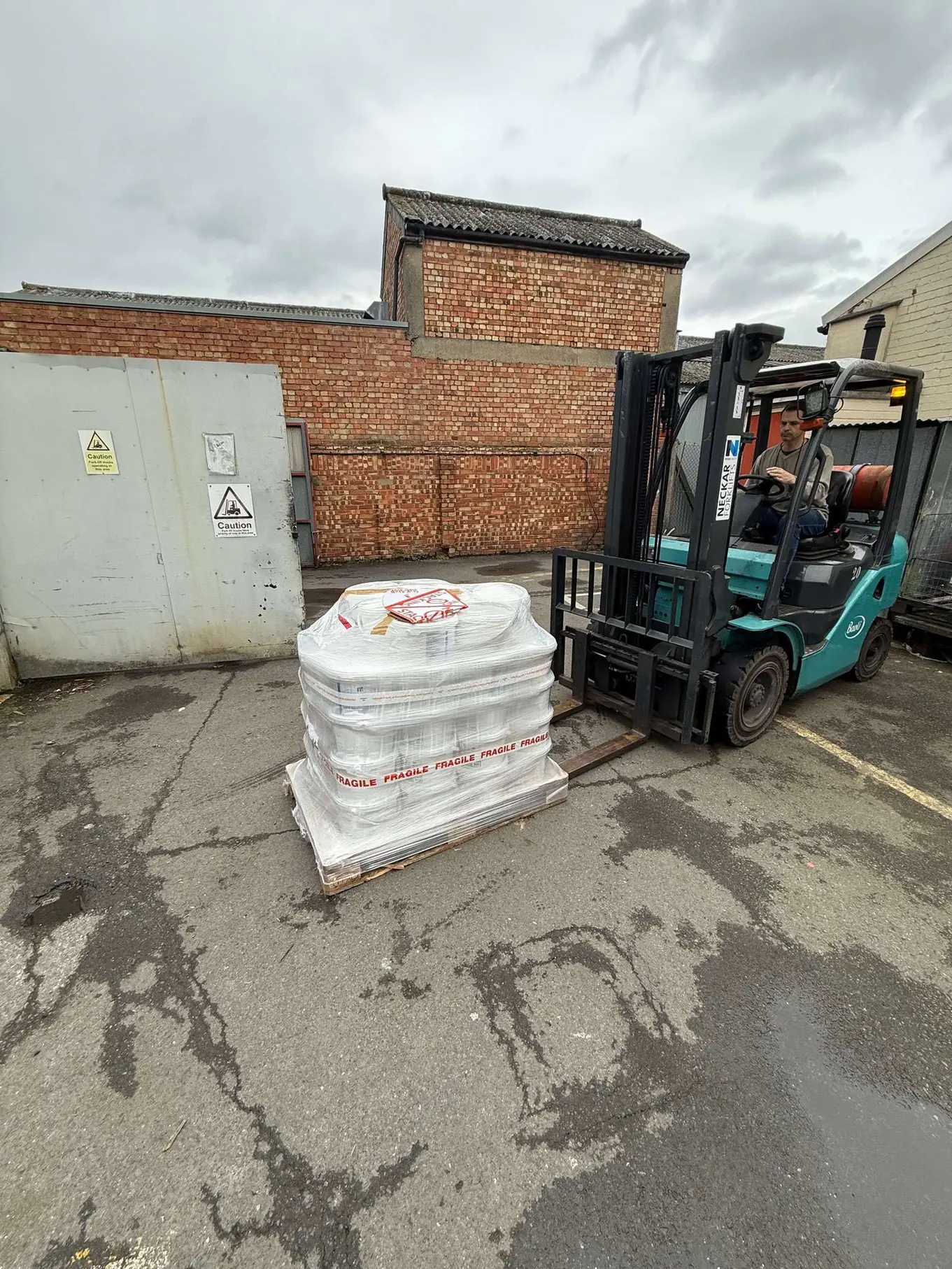 Forklift beside a pallet of bagged materials outside Deptford Store House
