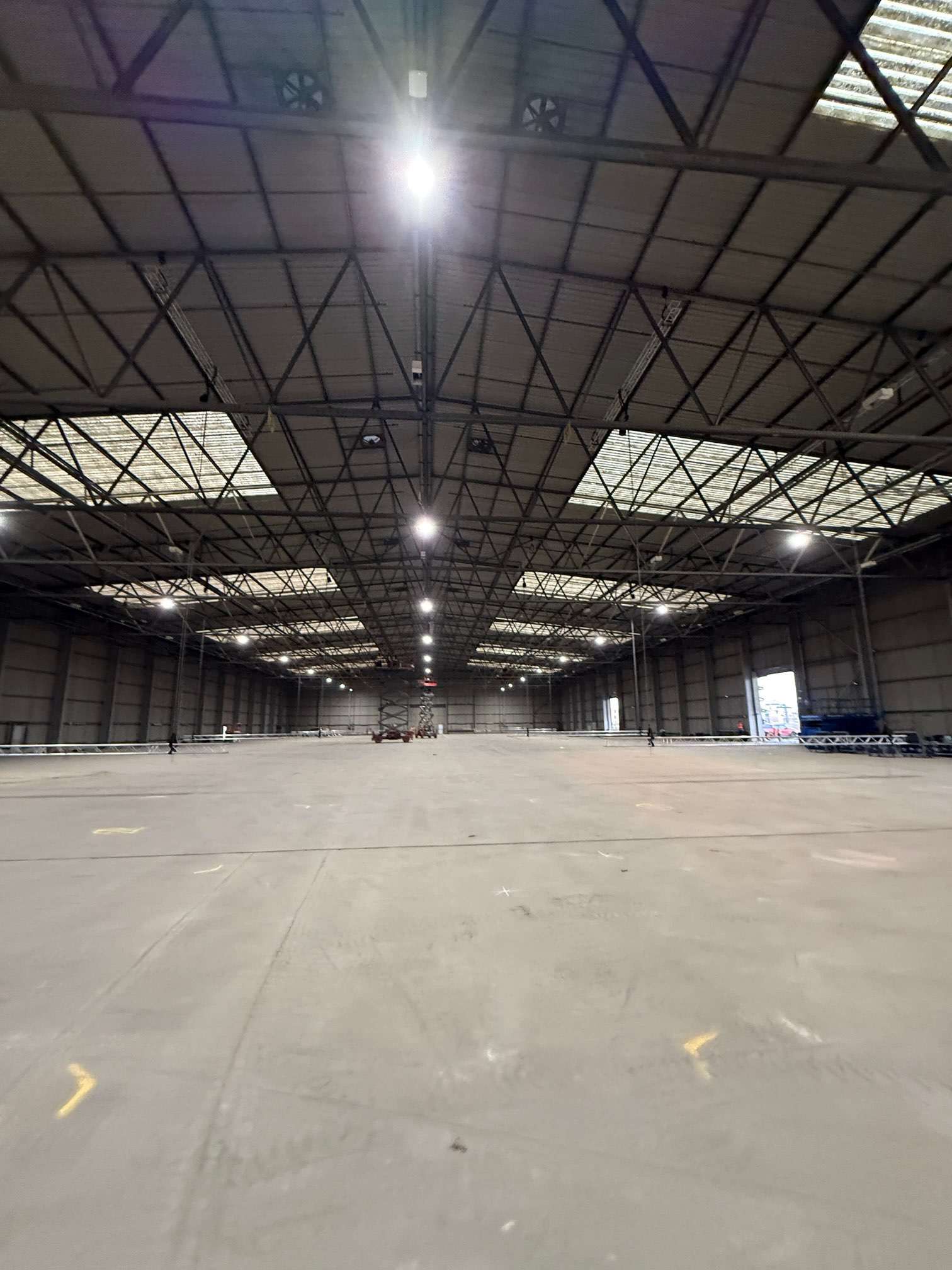 Open warehouse floor beneath roof trusses and rooflights at Deptford Store House