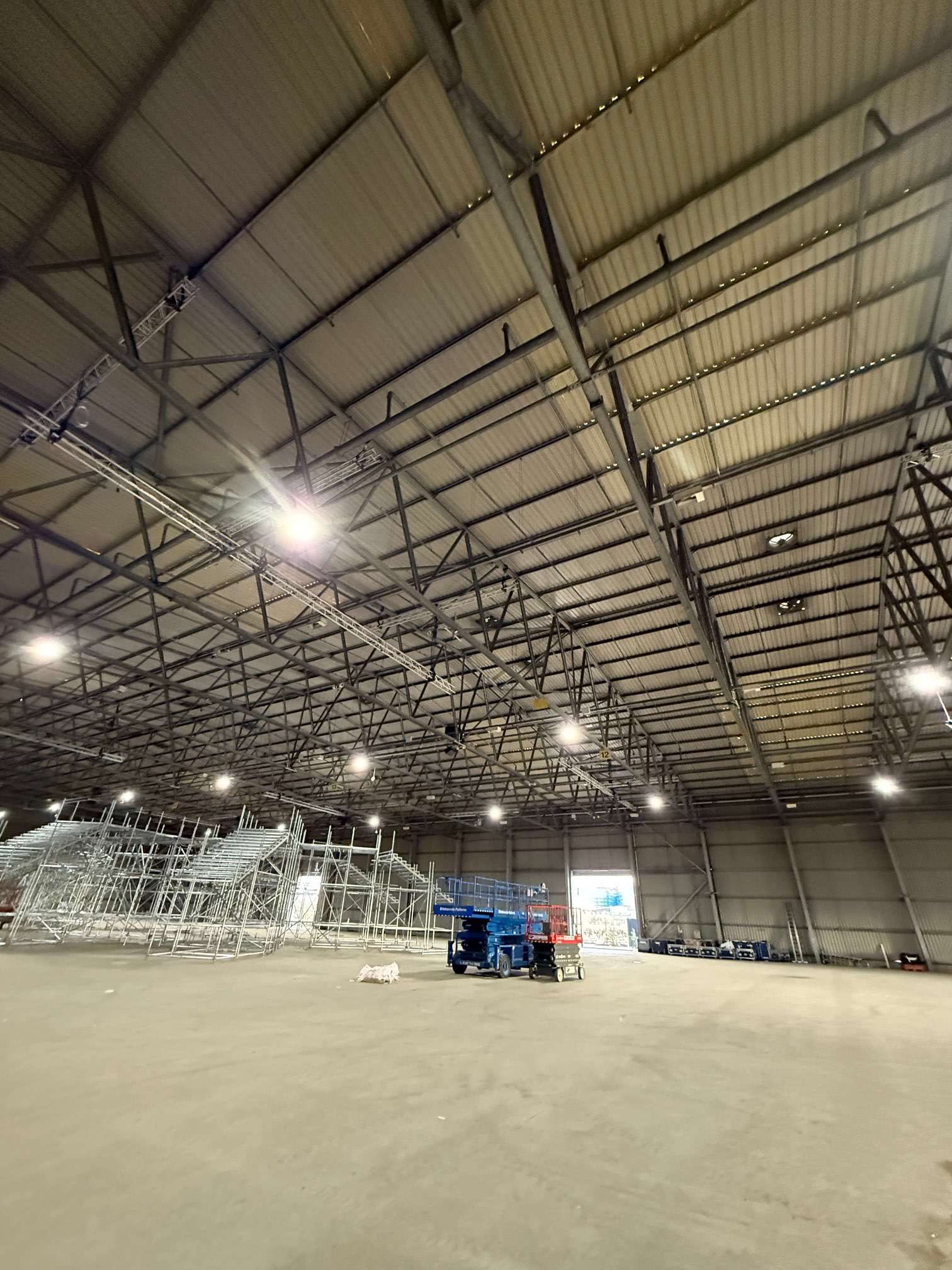 Warehouse interior with scaffolding and a blue access platform