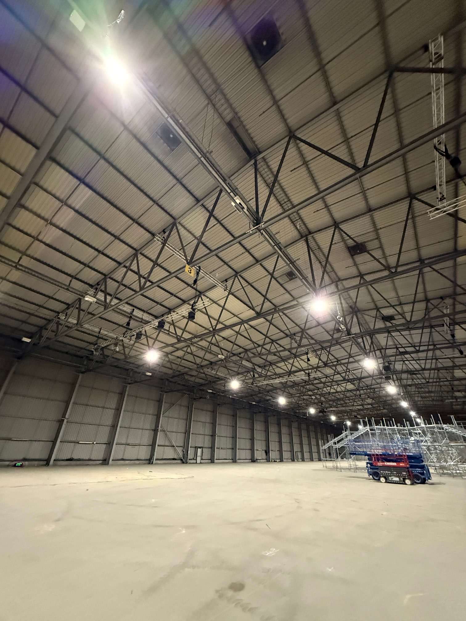 Wide view of warehouse roof trusses, lighting and access equipment