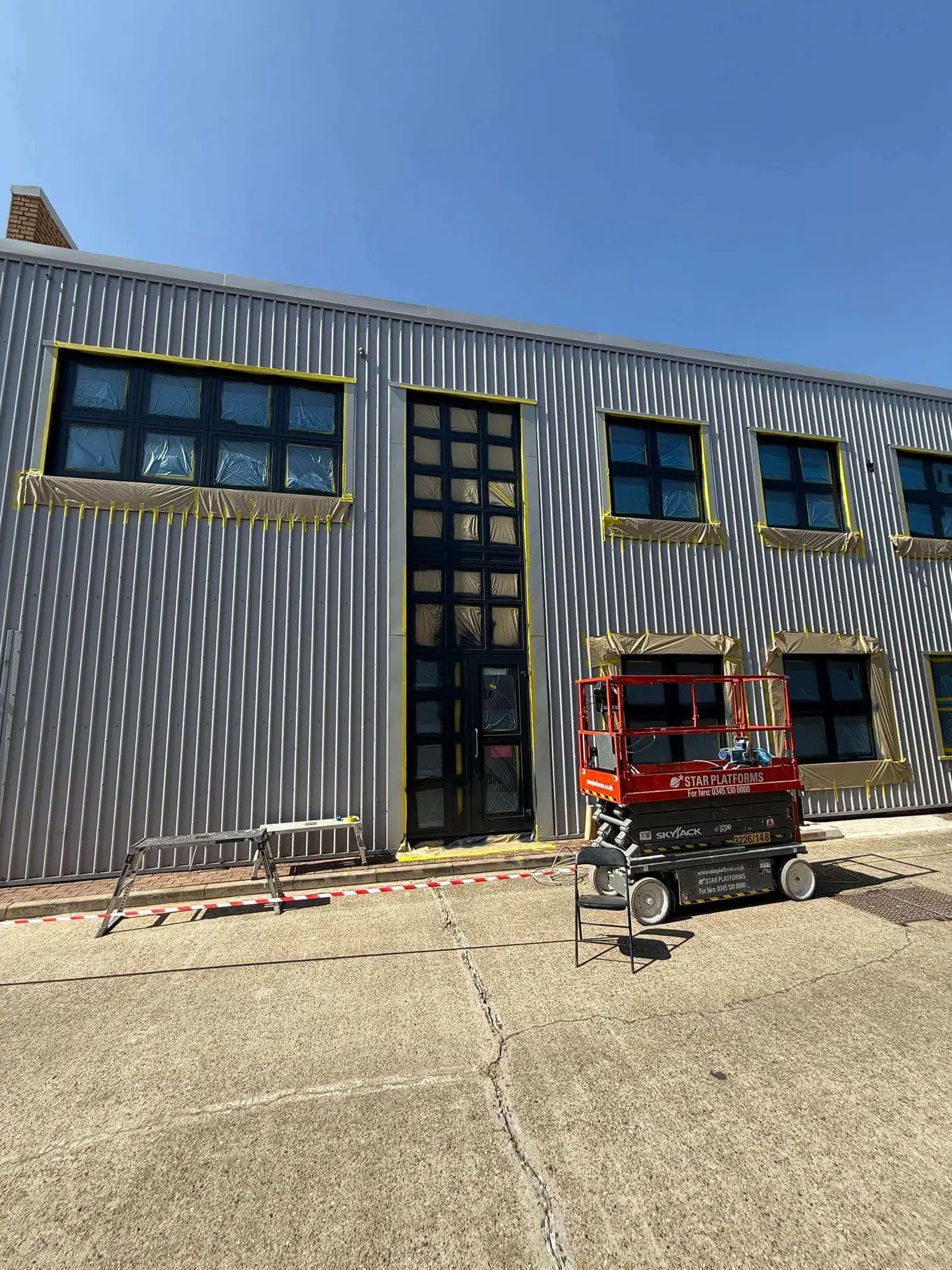 Dark entrance framing and masked windows with an access platform outside.
