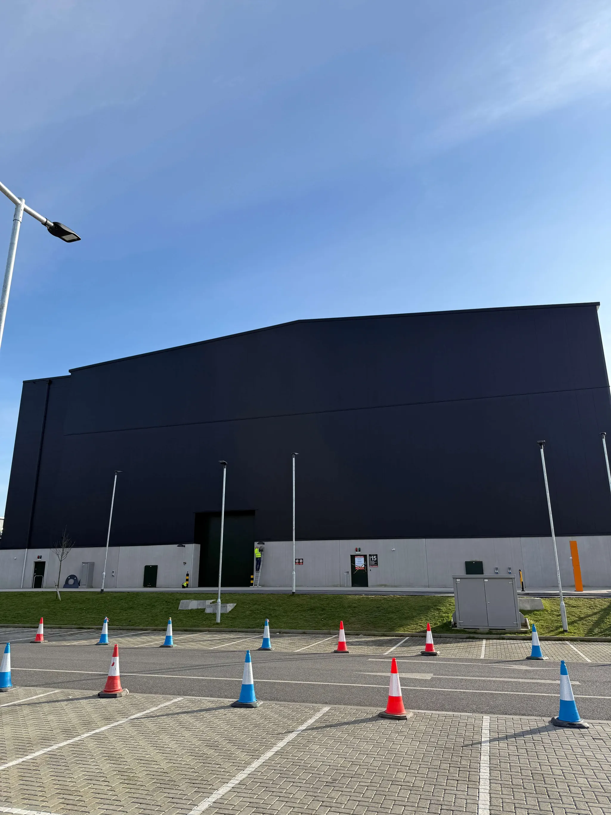 Black-clad studio building behind a car park at Shepperton Studios