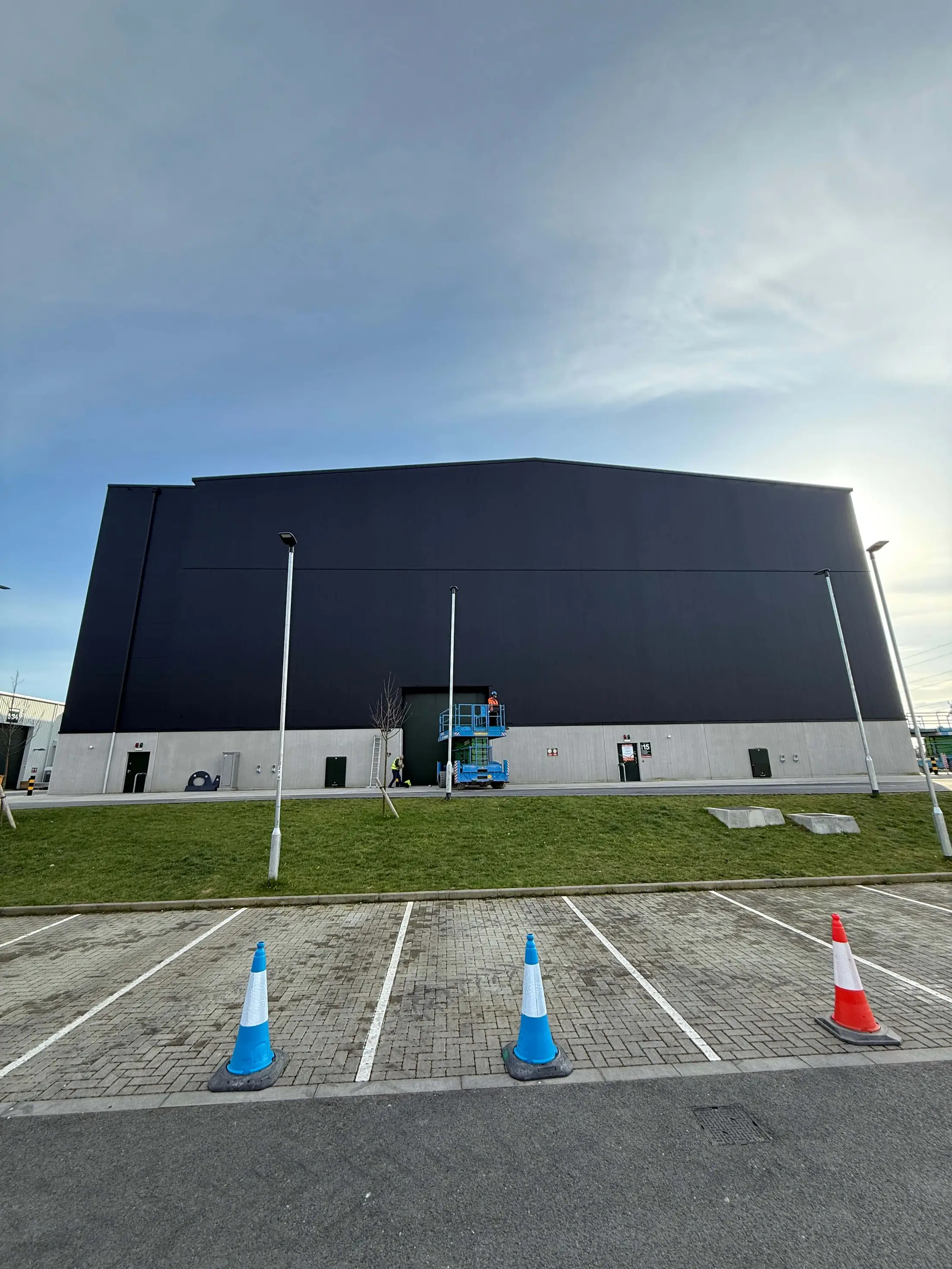 Black-clad studio facade with an access platform beside the entrance