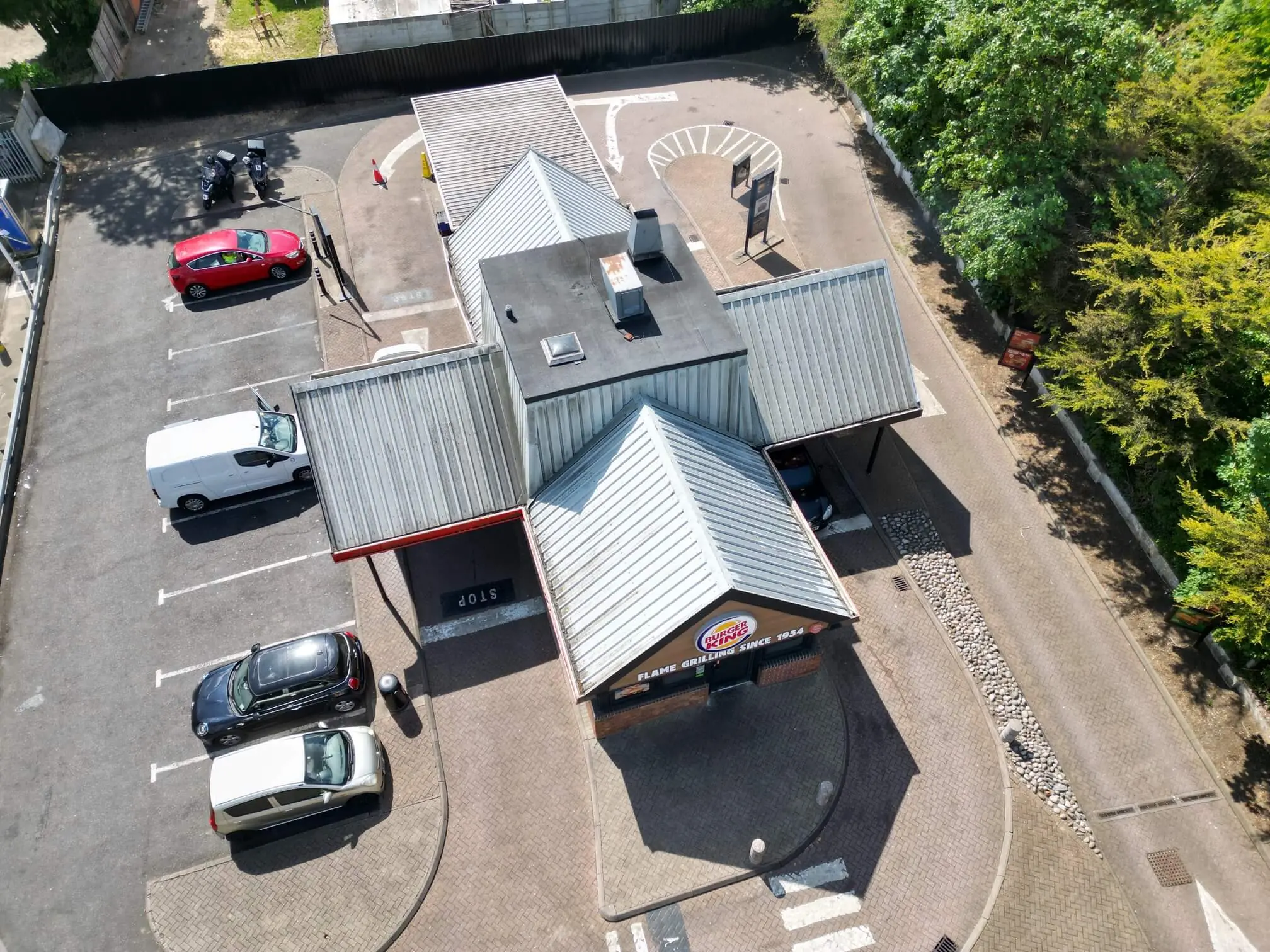 Burger King restaurant roof and surrounding car park viewed from above.