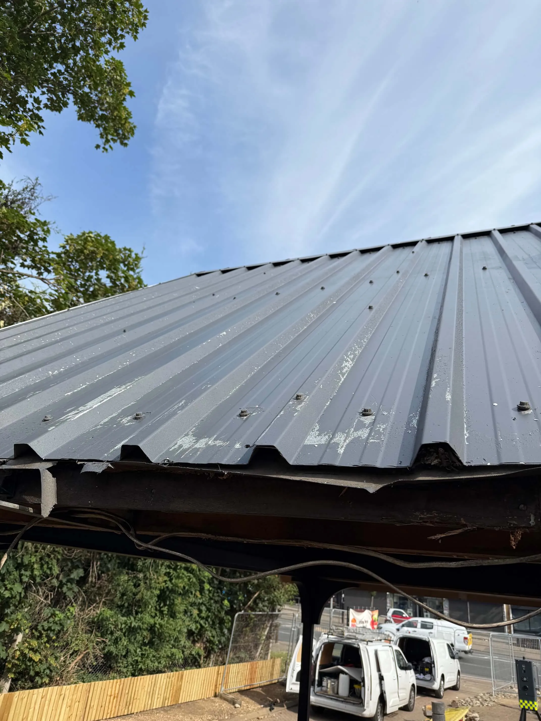 Flaking coating near the lower edge of a profiled metal roof.