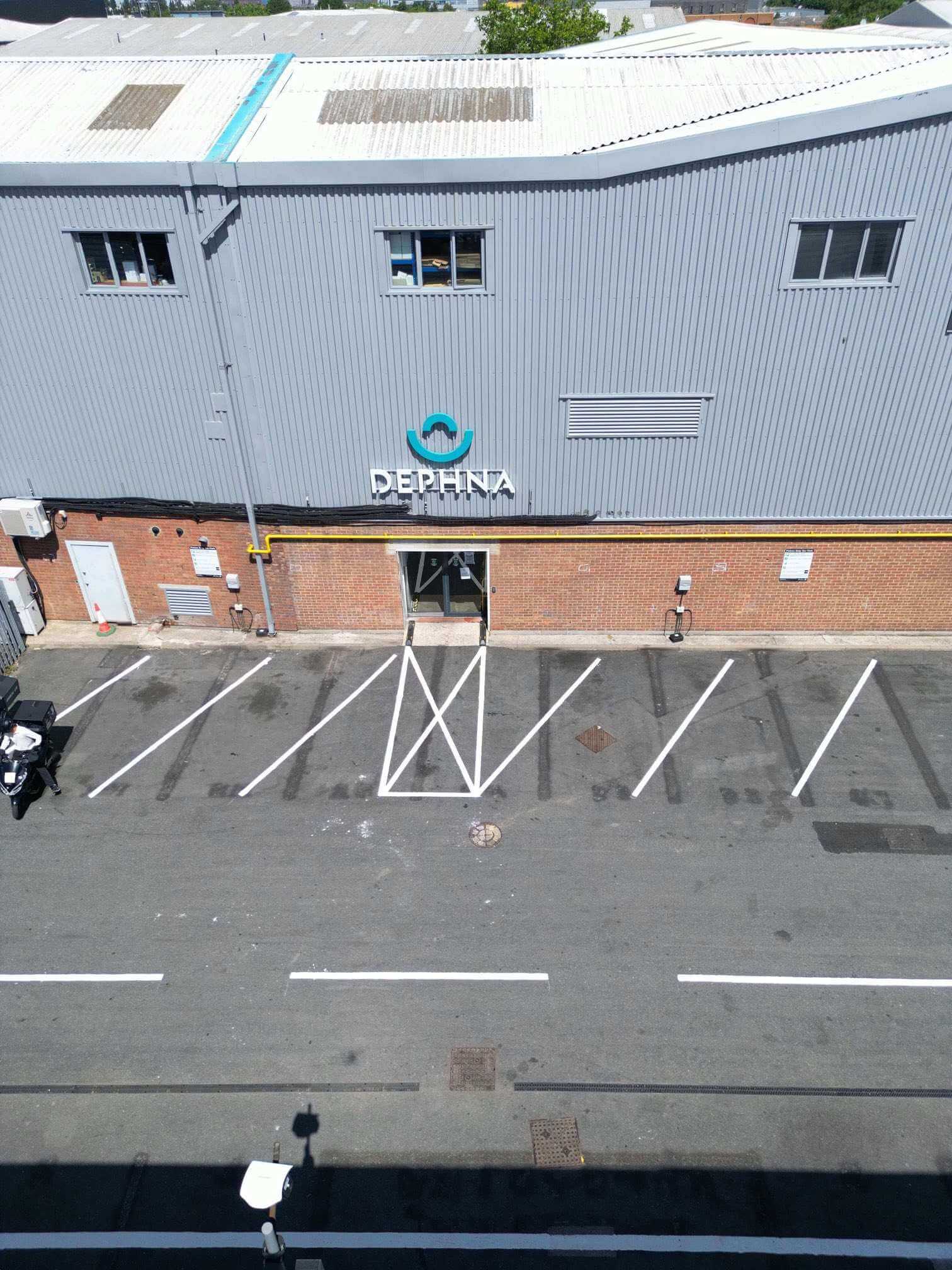 Marked parking bays and a hatched pedestrian access area outside an industrial unit.