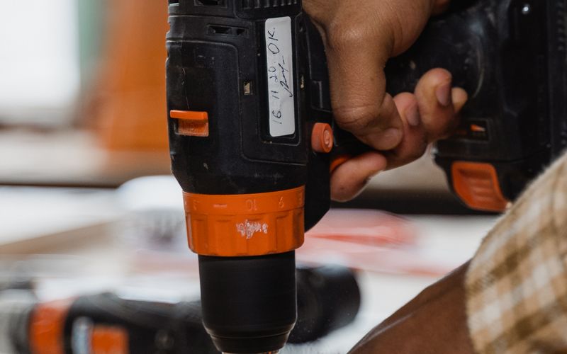 Hands using a power drill on wood