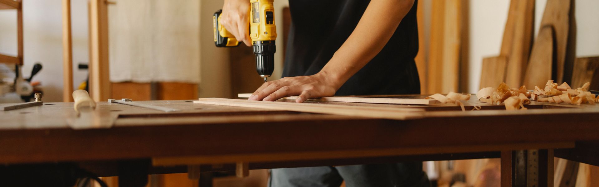 Carpenter drilling wooden floor plank