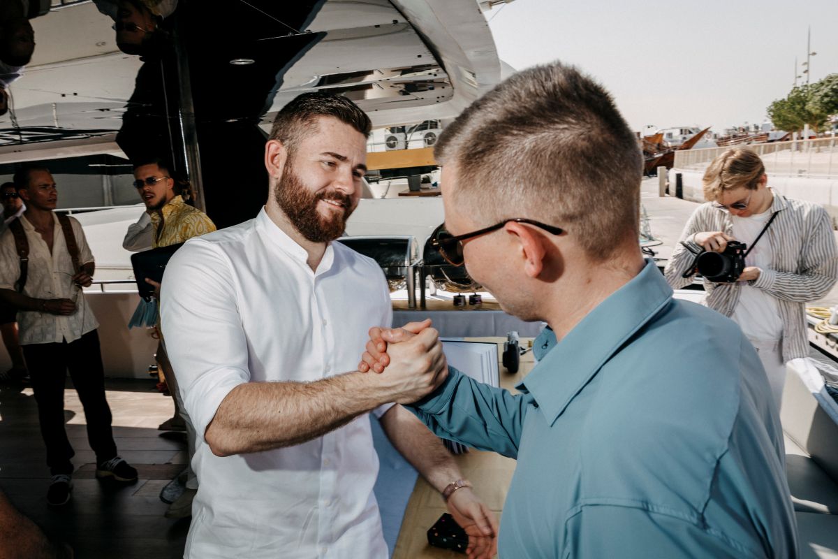 Netzwerk-Event: Handschlag zwischen zwei Partnern auf einer Yacht