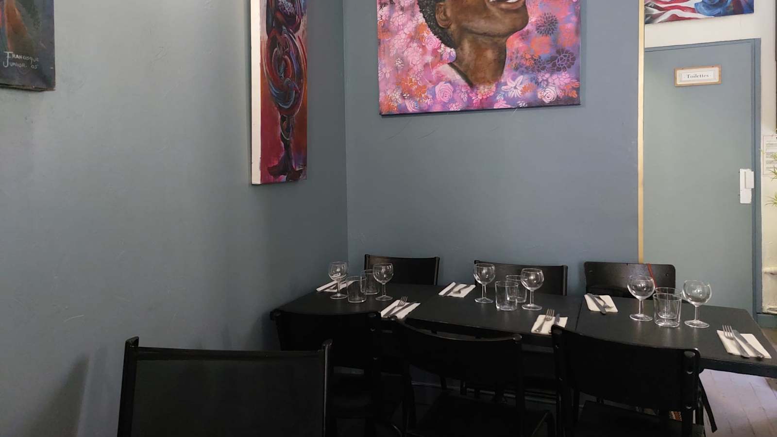 Salle du restaurant Katoro, murs bleus et toiles colorées du chef Junior Francisque
