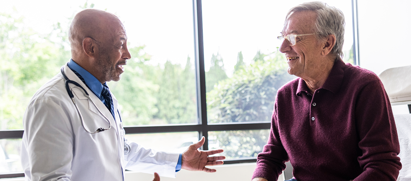Doctor having a conversation with older patient in a medical office