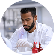 A man in a white lab coat working with gloves on