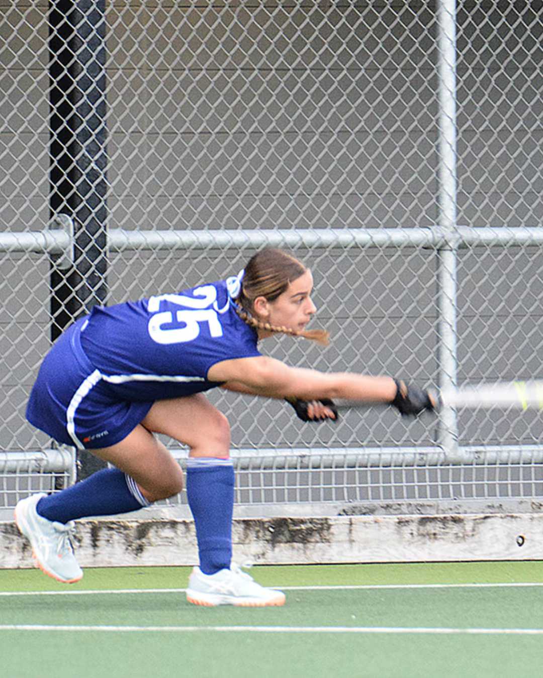Britta Laurenson playing the ball during a field hockey match