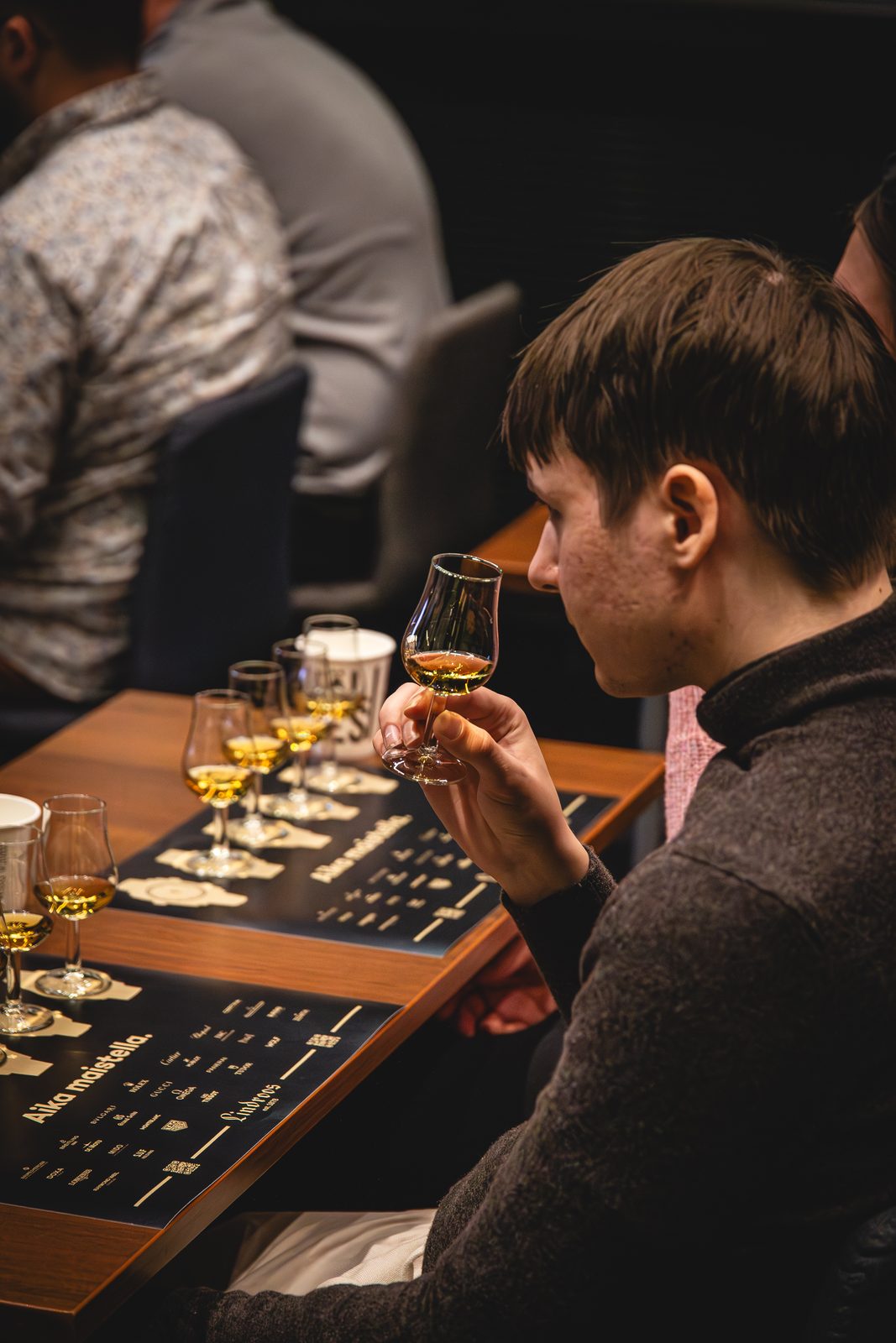 A visitor noses a glass of whisky at a tasting table at HDF Whiskey Edition
