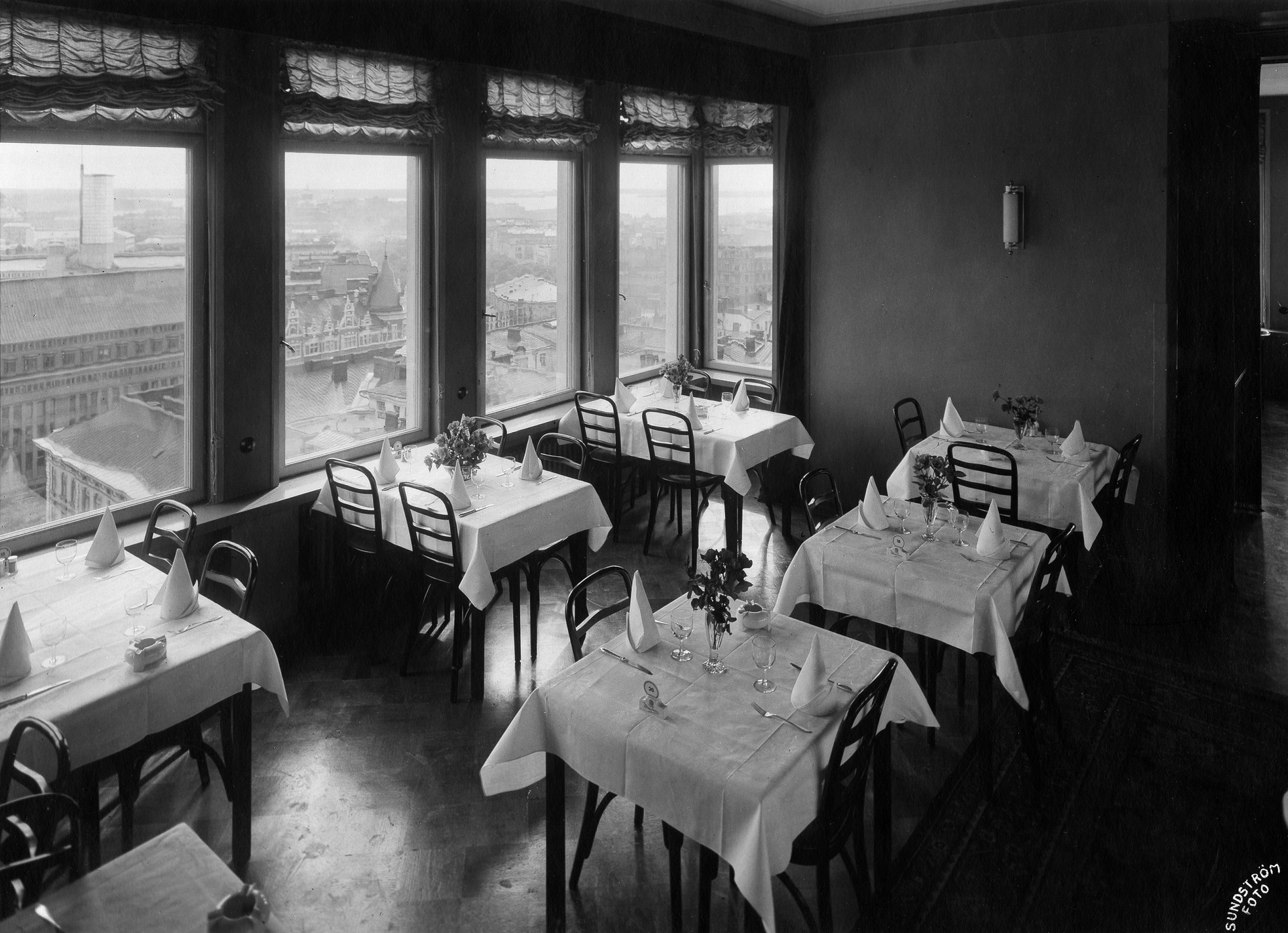 Hotelli Tornin ravintolasali 1930-luvulla, katetut pöydät ja ikkunoista näkymä Helsingin kattojen yli