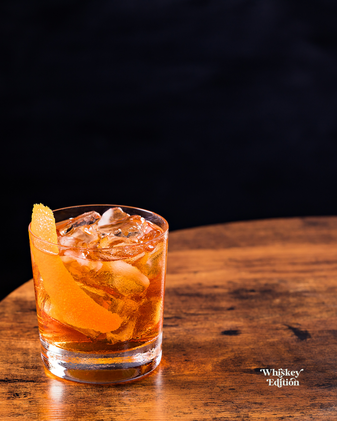 Old Fashioned in a rocks glass with ice, garnished with an orange twist