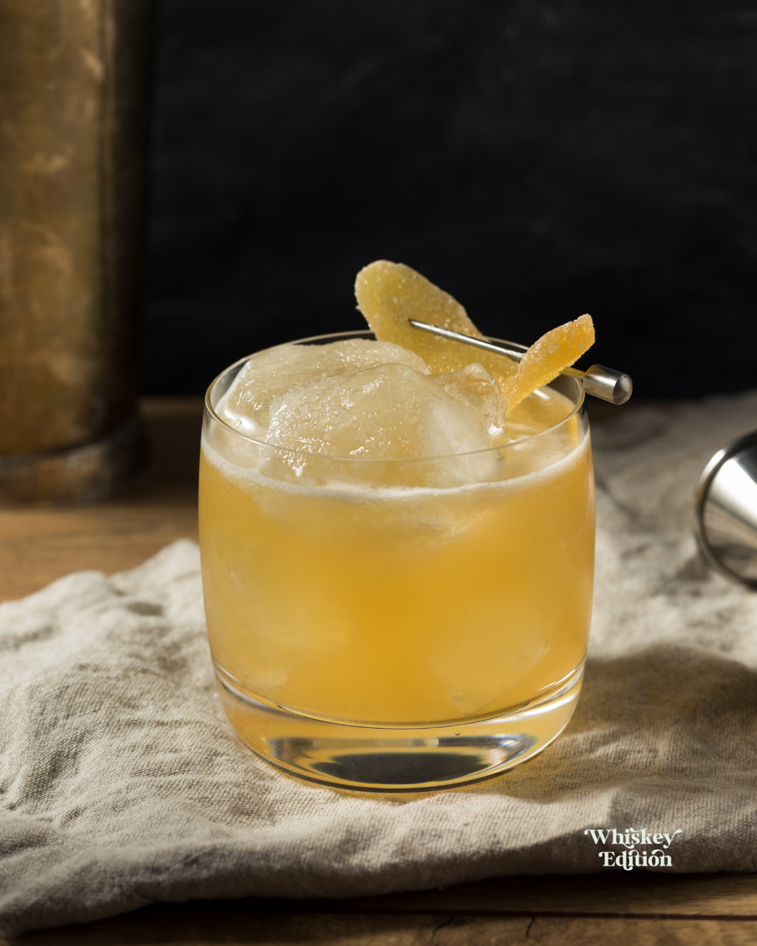 Penicillin in a rocks glass over ice, garnished with candied ginger