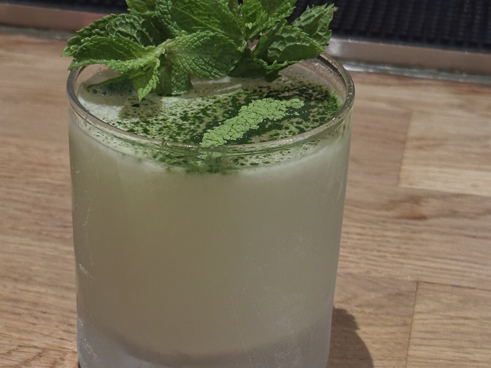 Mintchata cocktail with mint and matcha garnish at Gate A21