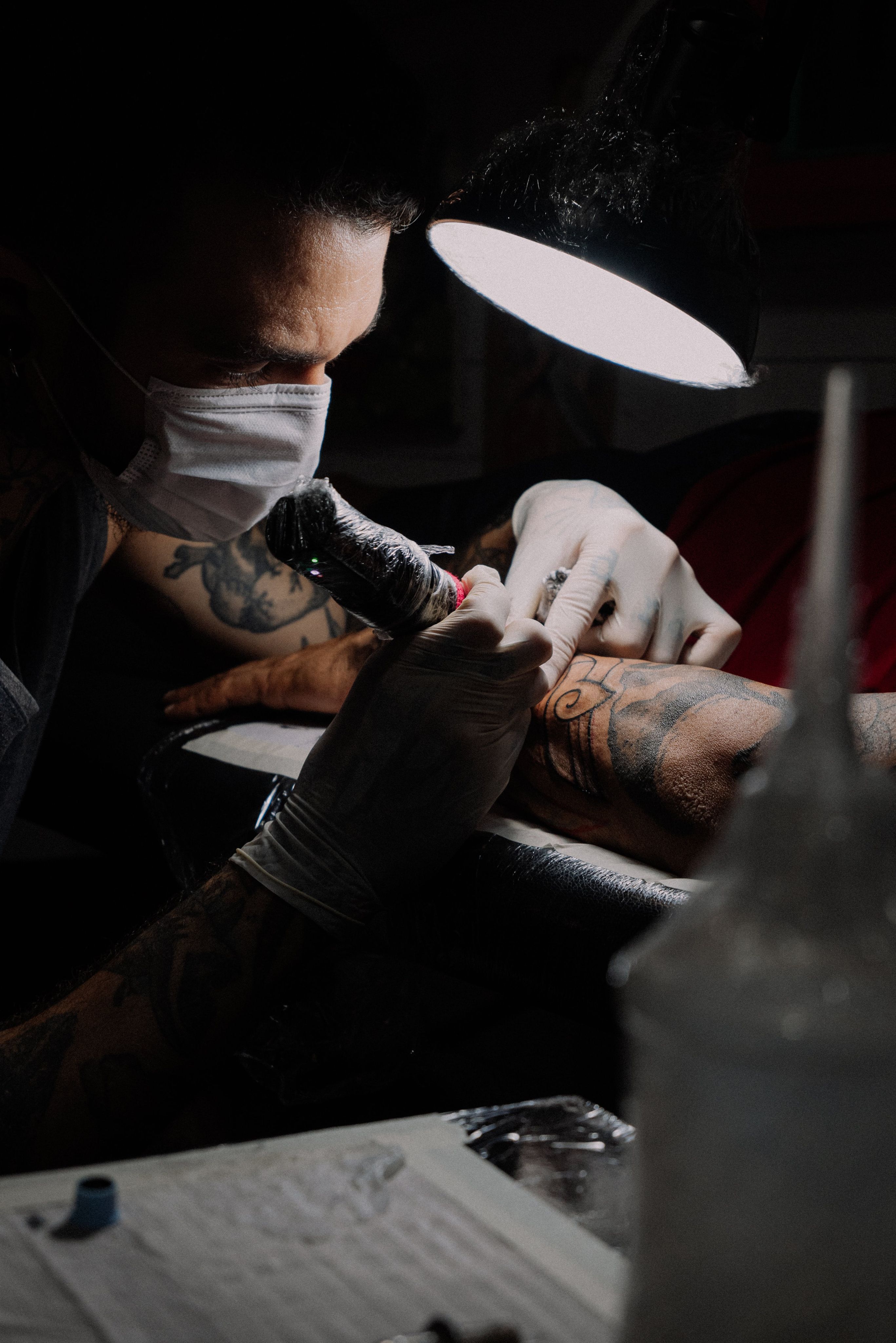 Tattoo artist working with protective gloves