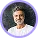 Smiling man with curly hair and beard wearing a white shirt against a blue background.