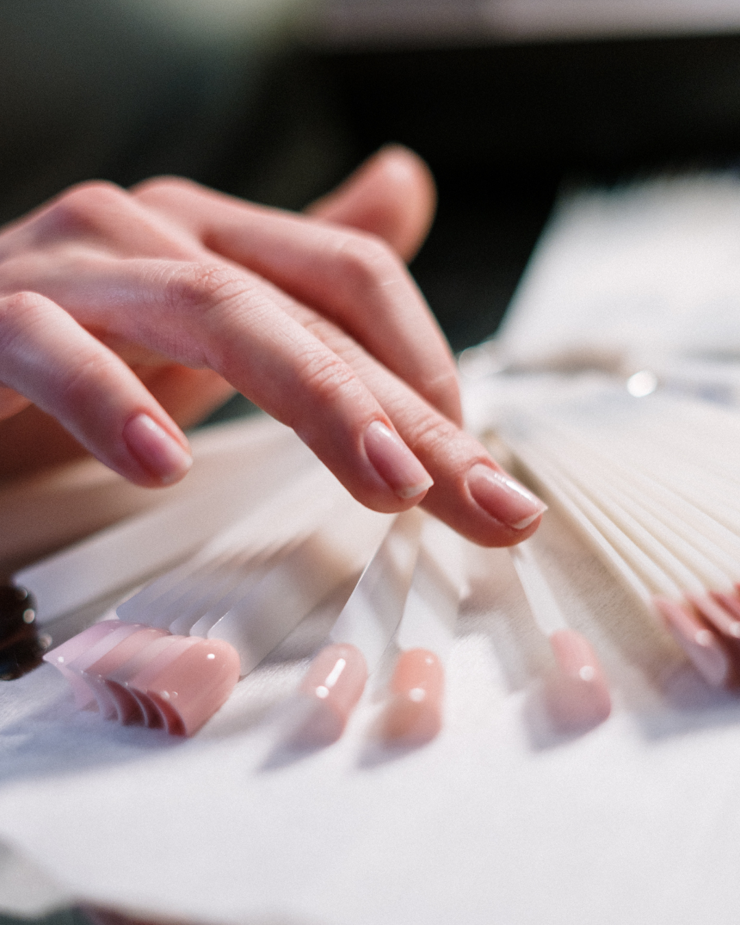 A guest choosing from a display of nail tip samples