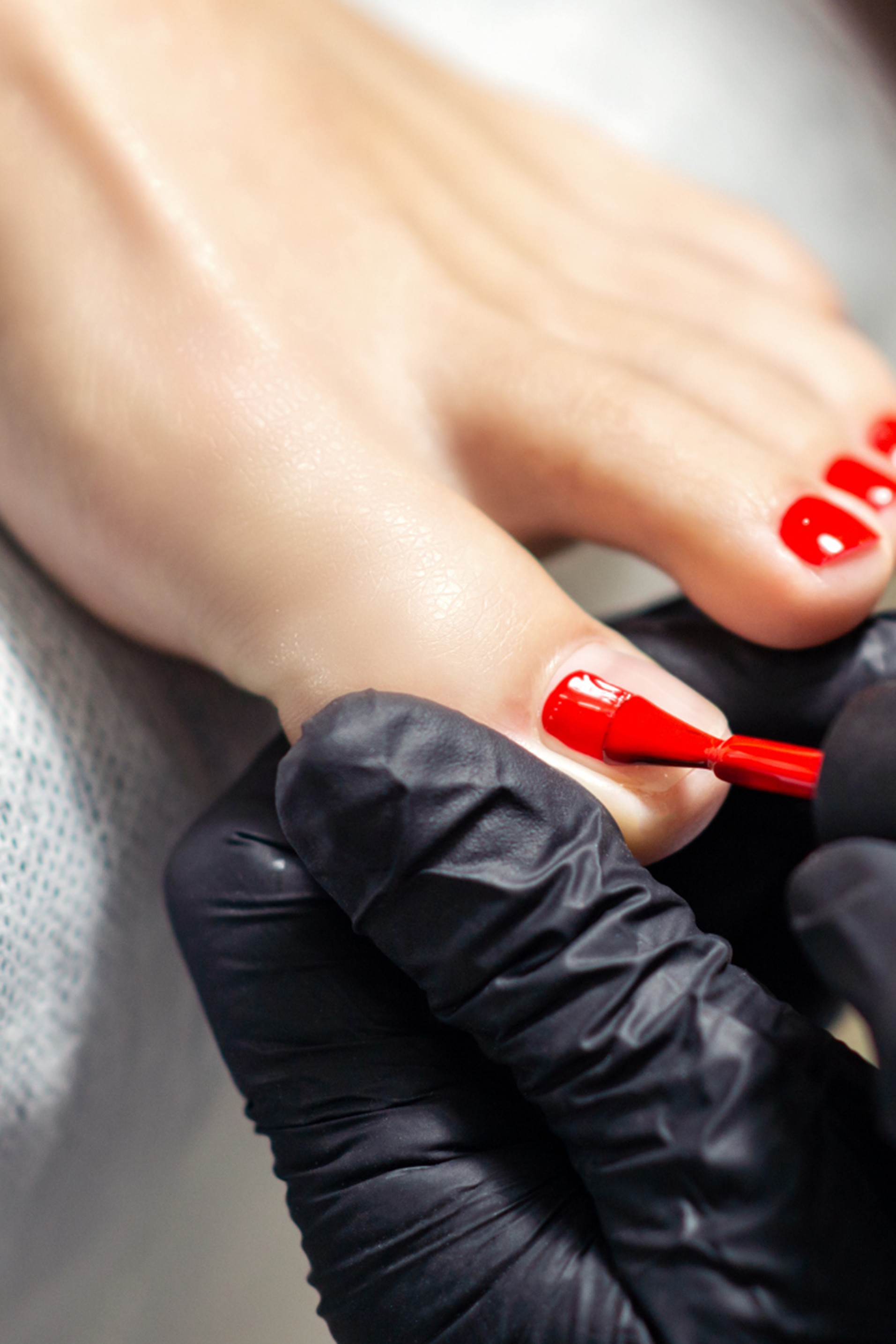 Red polish being applied during a pedicure