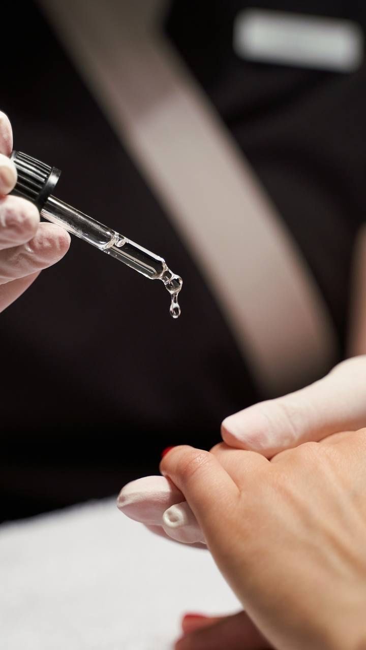 Cuticle oil being applied during a manicure