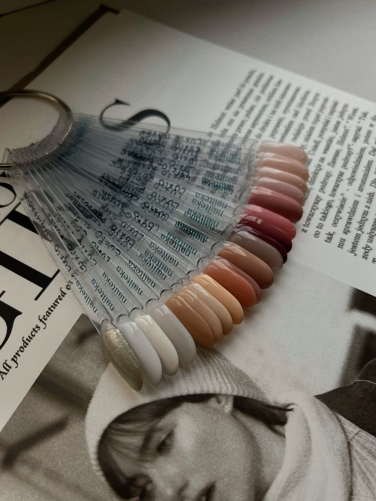 A fan of neutral polish shades resting on an open magazine
