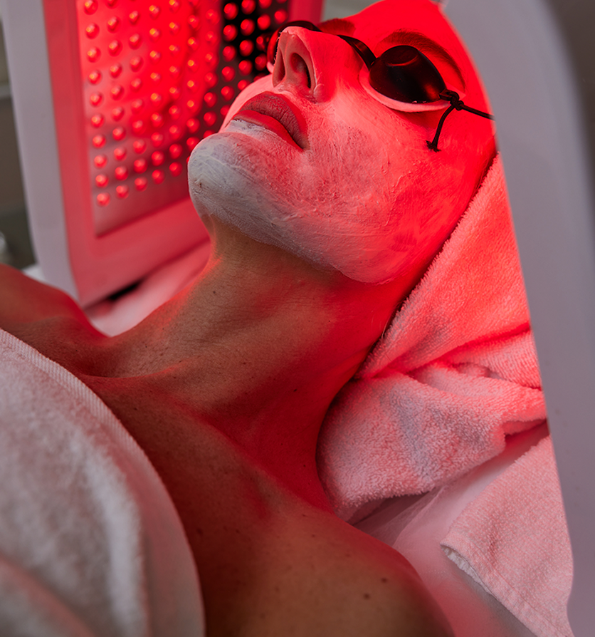 A guest receiving red light therapy while wearing protective goggles