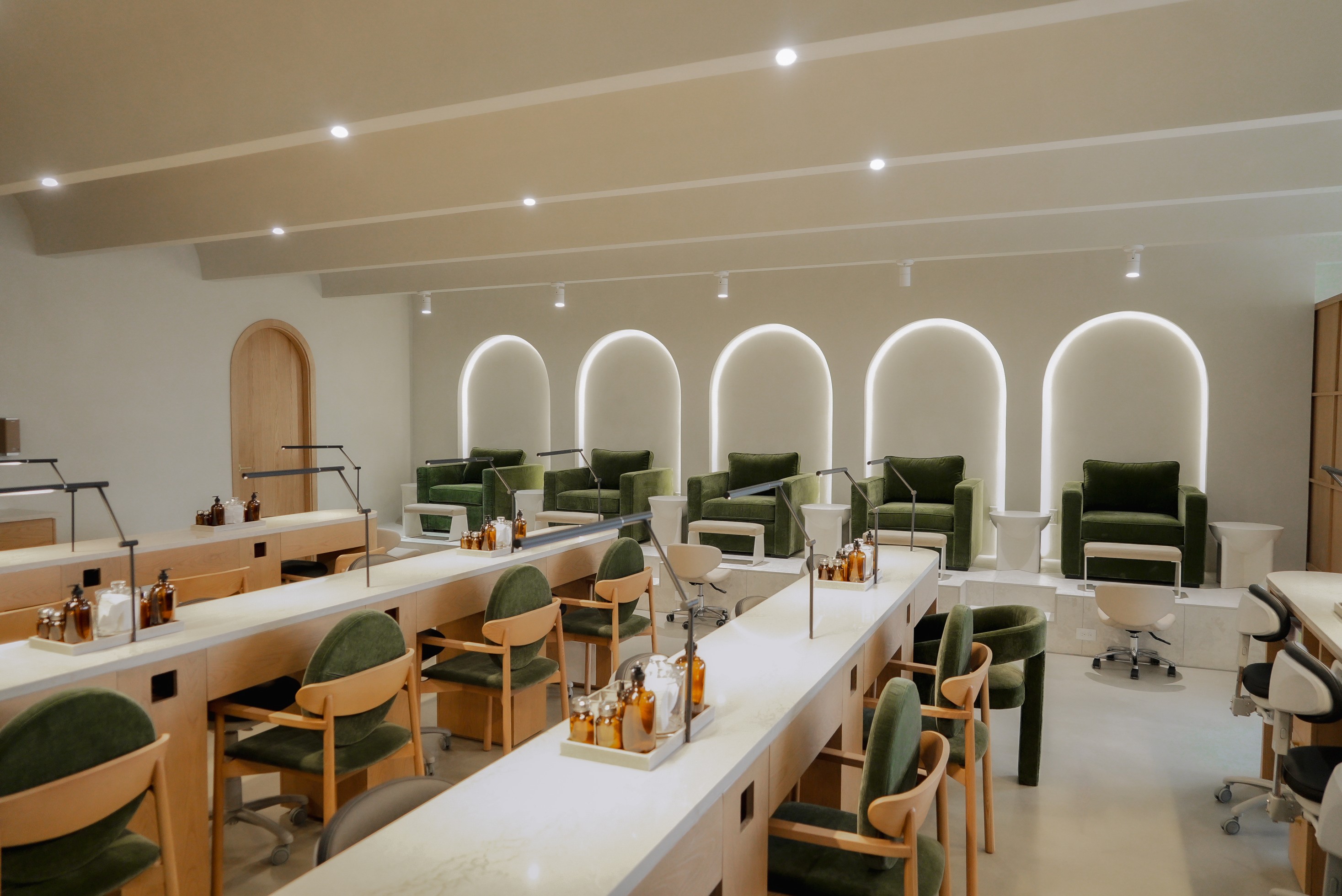 Manicure stations beneath backlit arches at Earth Nail Spa