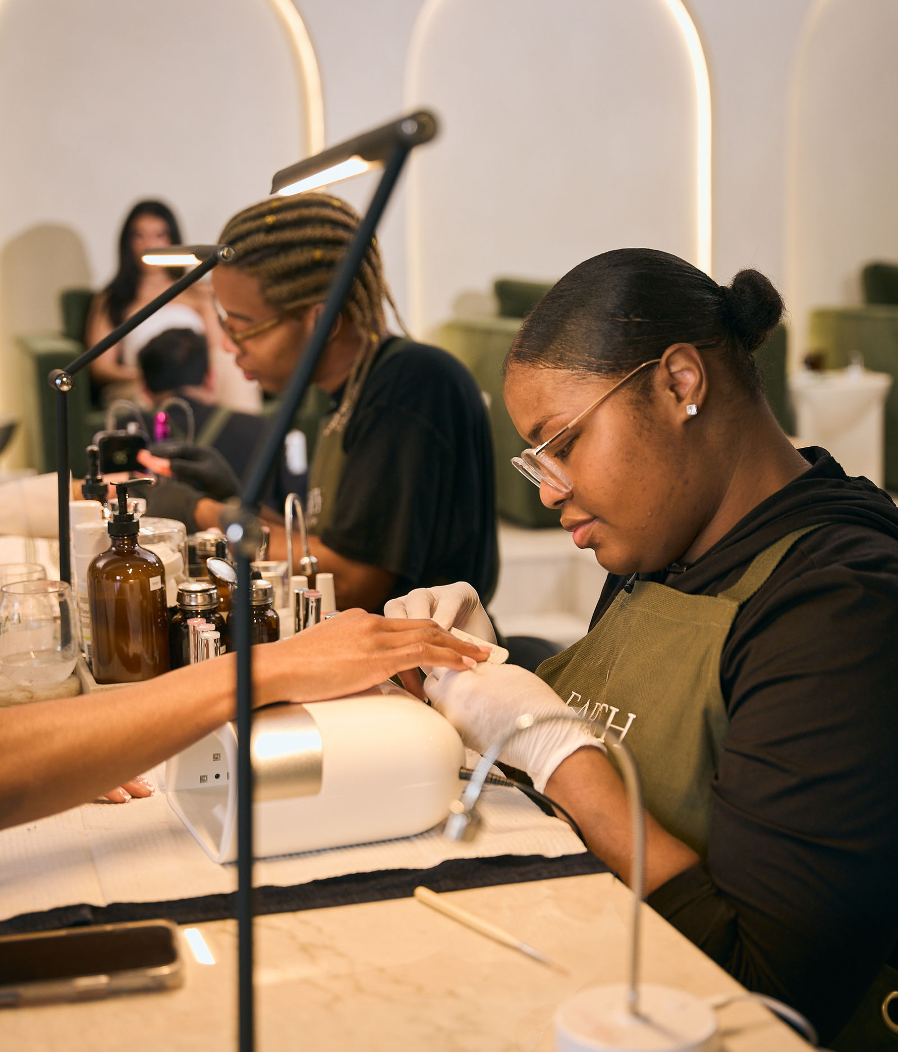 Technicians working with guests at the manicure bar