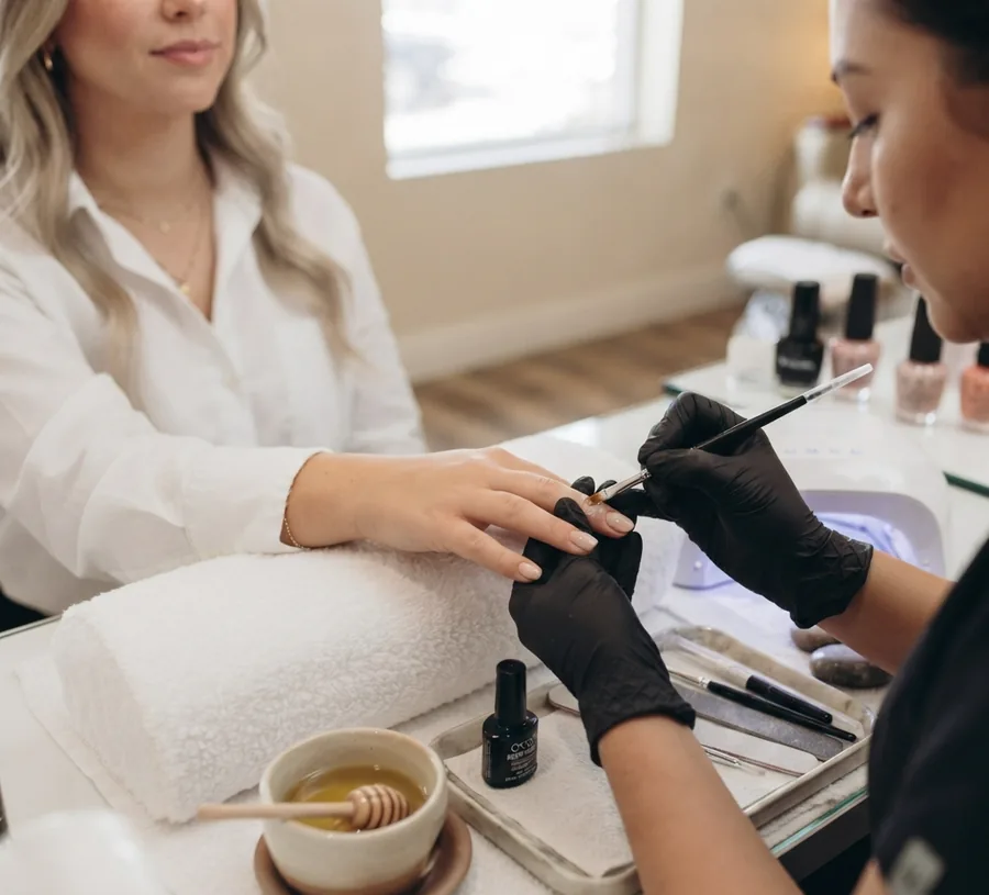 Glossy gel manicure being finished under a curing lamp