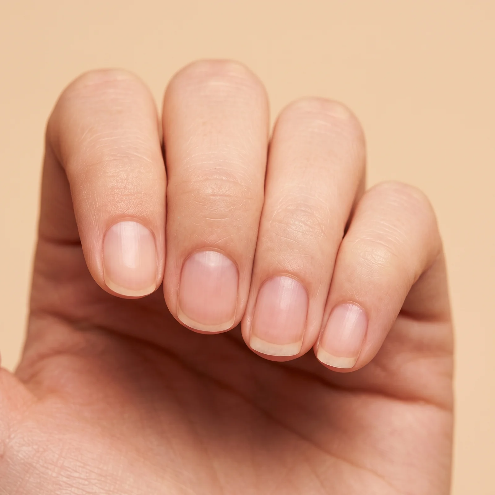 Short bare natural nails with smooth even surfaces, healthy pink nail beds and neat cuticles