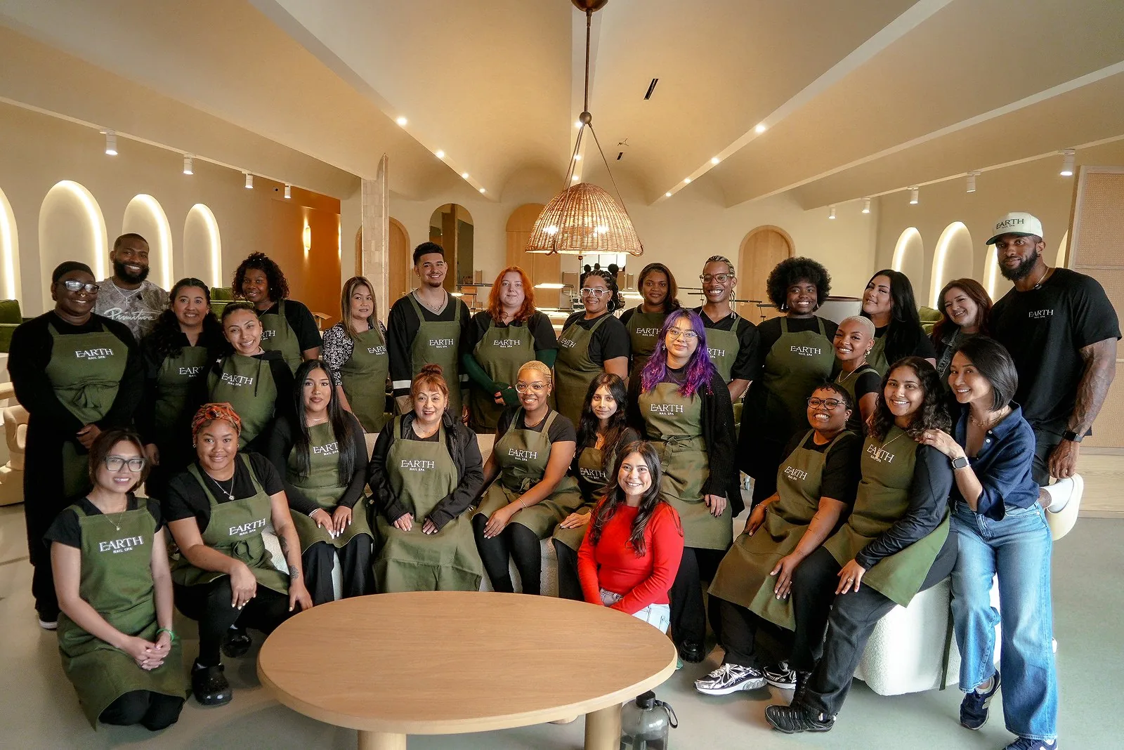 The Earth Nail Spa team together in the studio, wearing Earth aprons