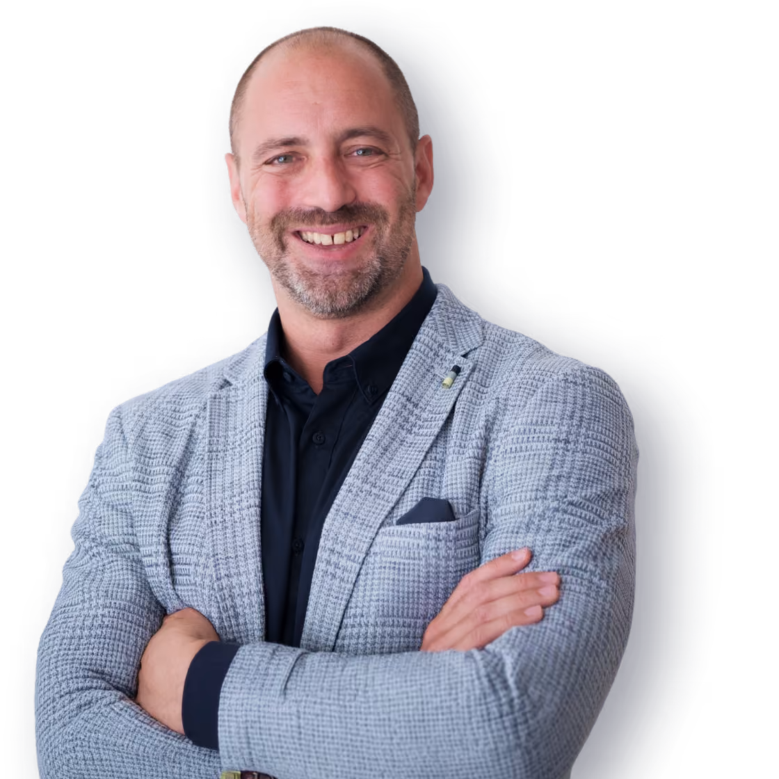 Smiling bald man with a beard wearing a gray checkered blazer and black shirt, arms crossed.