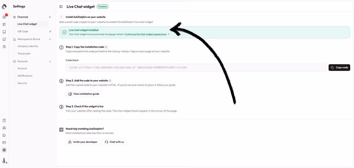 AskDolphin installation screen showing a green ‘Live chat widget installed’ status with an arrow pointing to the confirmation message.