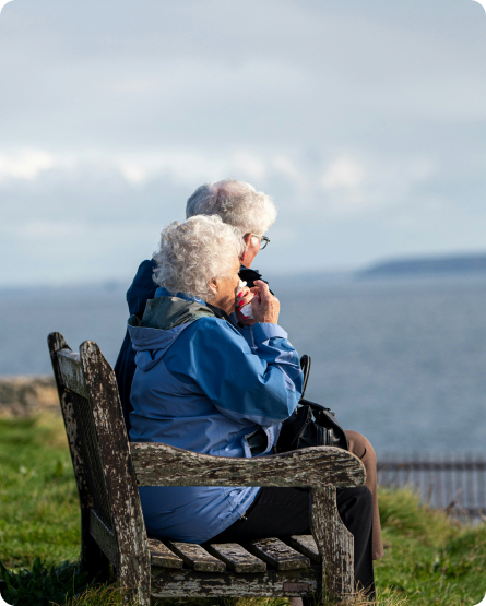 Elderly couple sitting together outdoors