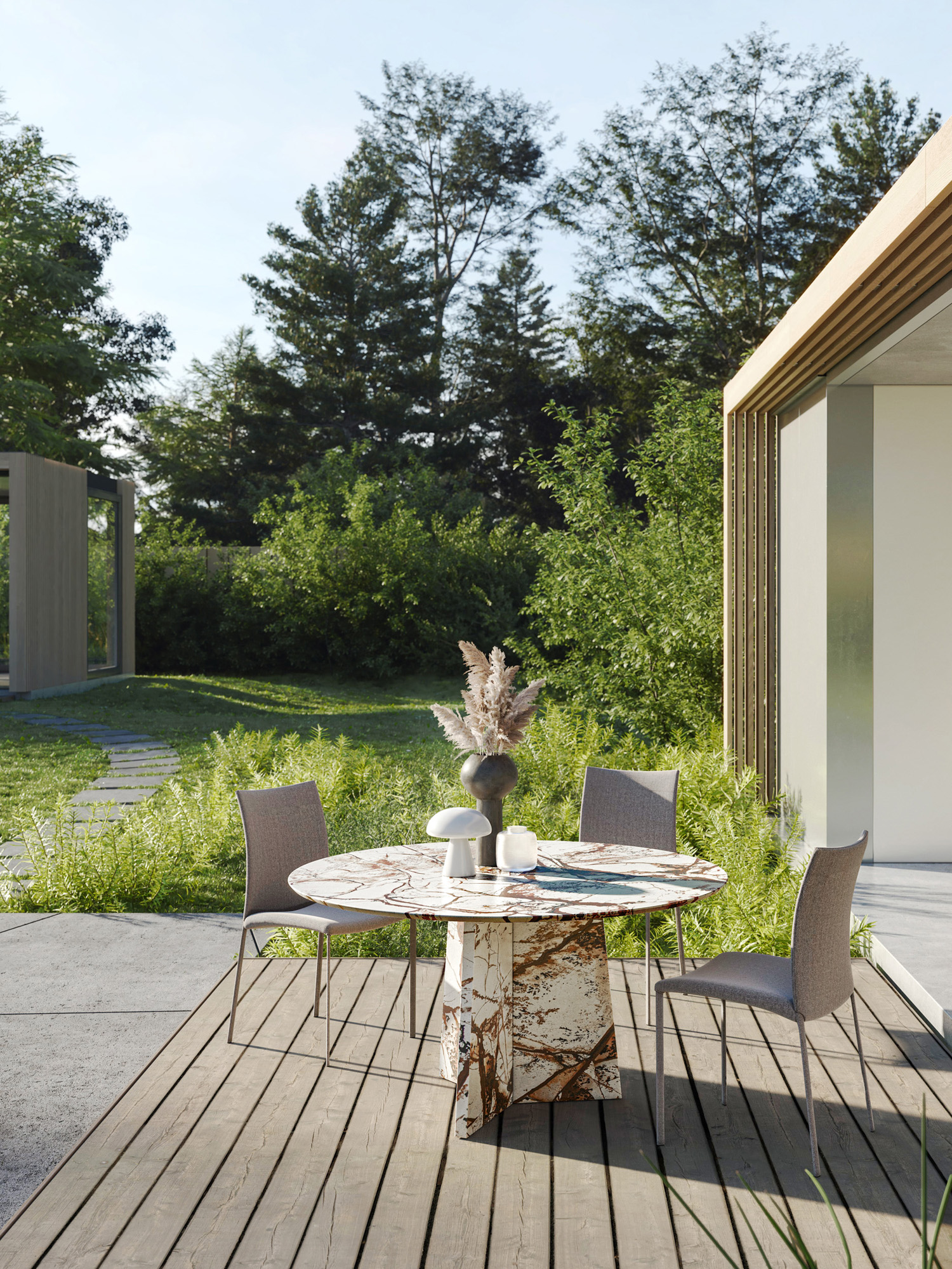Sunlit wooden terrace with an outdoor dining table beside a modern house and landscaped garden.