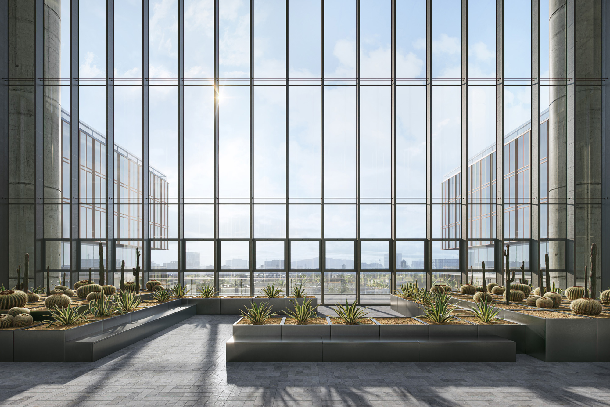 Indoor atrium with large glass windows, concrete columns, and planter boxes with cacti and succulents.