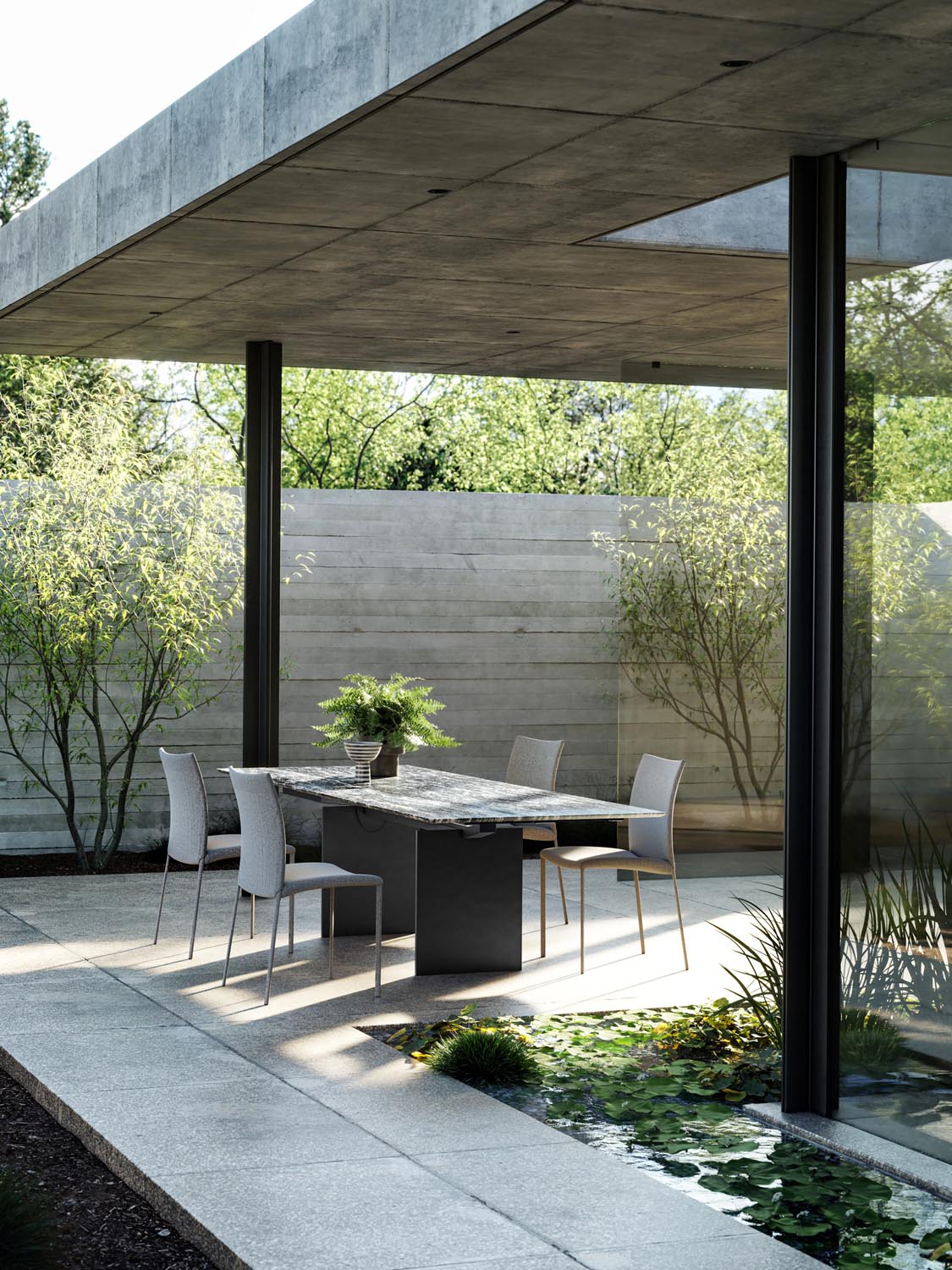Covered modern patio with an outdoor dining table beside a shallow reflecting pool and lush garden.
