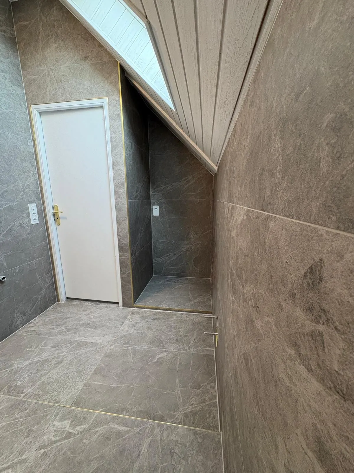 Niche sous pente carrelée dans une salle de bain à Crans