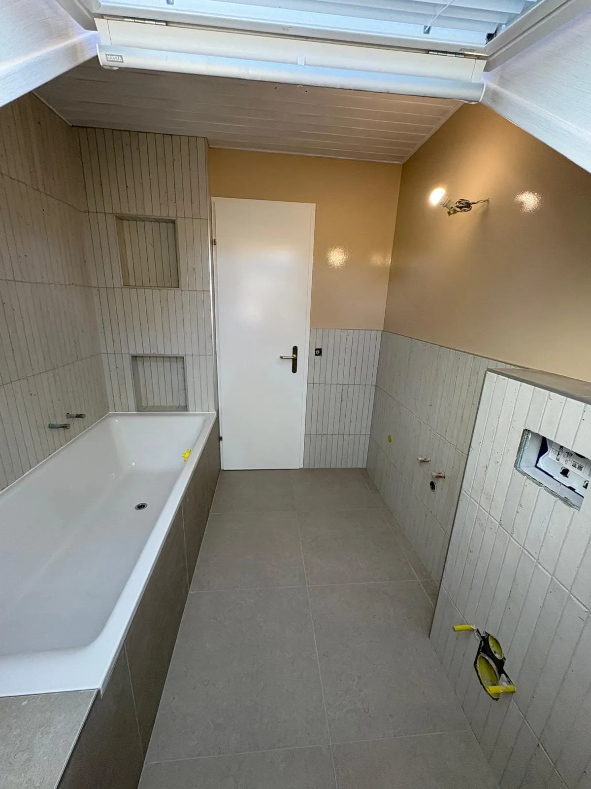 Vue d’ensemble de la salle de bain sous combles à Trélex après pose du carrelage
