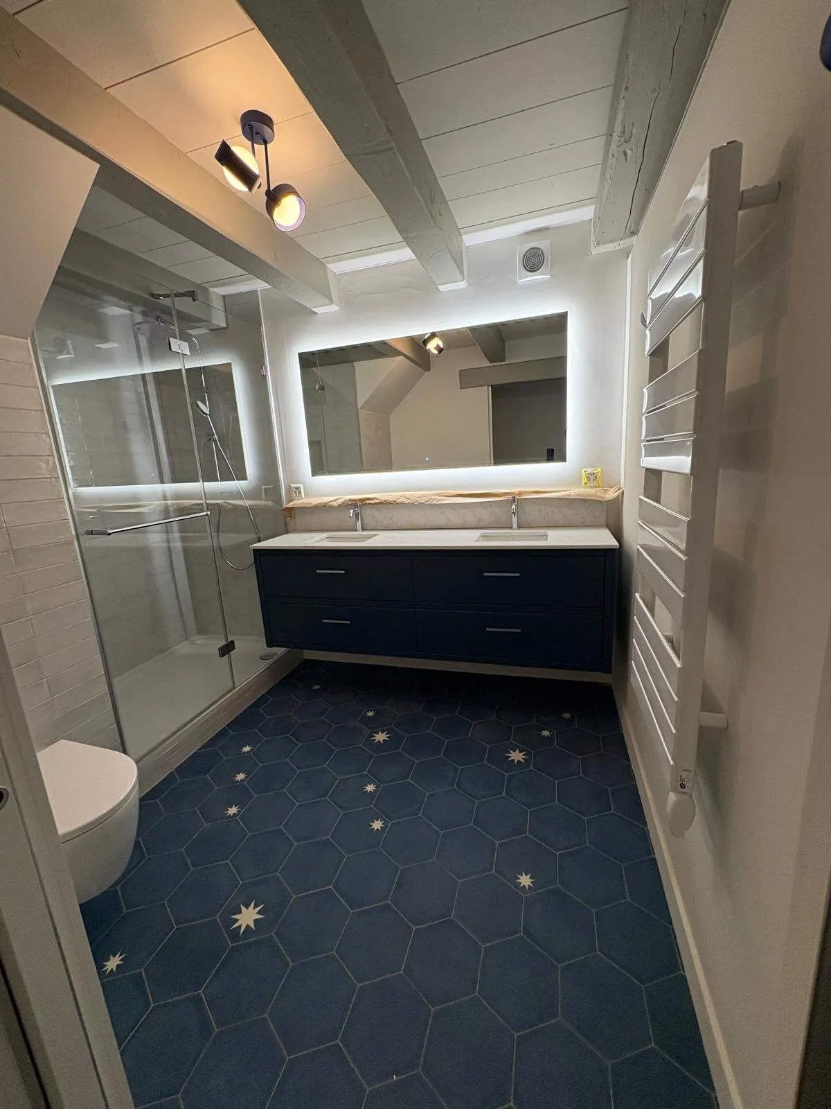 Salle de bain à Chéserex avec meuble double vasque et miroir rétroéclairé