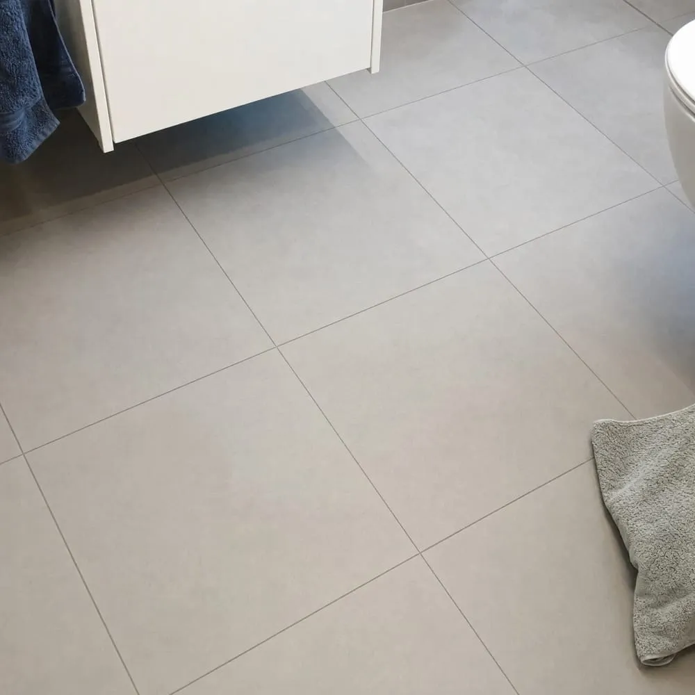 Sol de salle de bain en grands carreaux gris clair posés droit, joints alignés