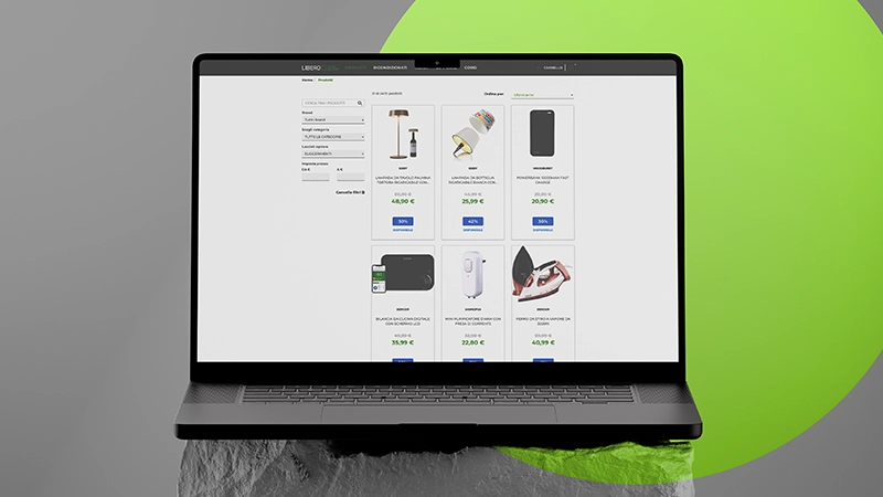 Portatile nero con schermo che mostra una pagina e-commerce con prodotti elettronici e sconti in euro.