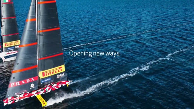 Due barche a vela con vele Pirelli e Prada che navigano su acqua blu con la scritta Opening new ways.