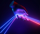 Mano futuristica che tiene fili di luce blu e rossa su sfondo nero.