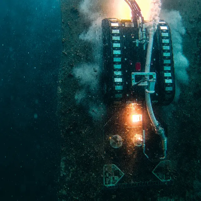 Cleaning robot working underwater on a submerged steel structure