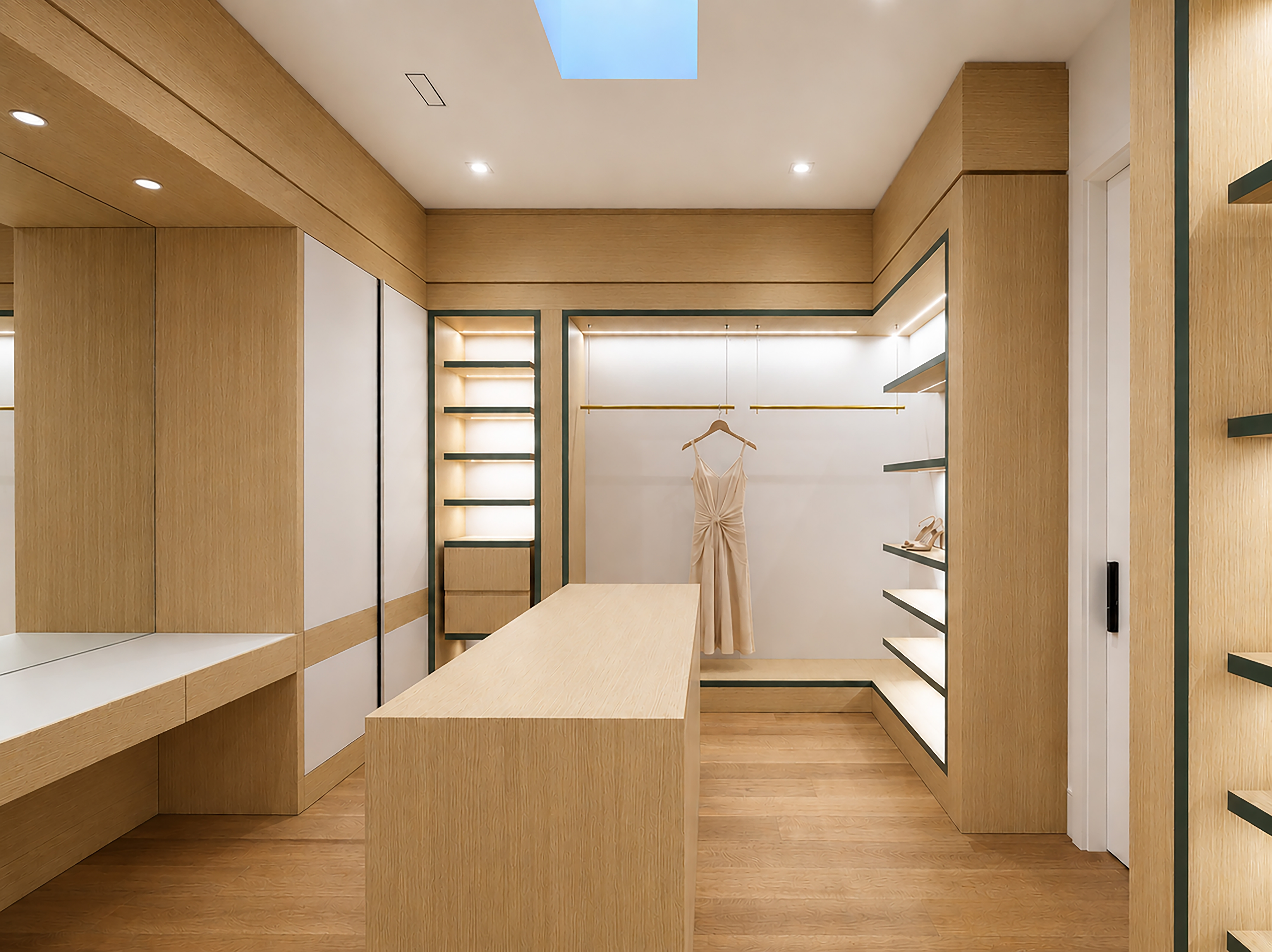 Custom walk-in closet with light wood cabinetry, central island, and skylight